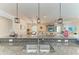 Open concept: Kitchen sink featuring granite countertops and island seating, with a view of the living room at 9283 Newnan Cir, Port Charlotte, FL 33981