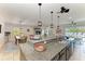 Open kitchen featuring granite counters, island seating, and seamless flow to the living and dining areas at 9283 Newnan Cir, Port Charlotte, FL 33981