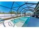 Inviting screened pool with sunny seating area, privacy fence and green landscaping at 9283 Newnan Cir, Port Charlotte, FL 33981