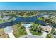 Gorgeous aerial view of a waterfront home featuring a canal, lush landscaping, and a private boat dock at 9404 Arnaz Cir, Port Charlotte, FL 33981