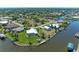 Aerial view showcases a waterfront home with a pool and dock, surrounded by lush landscaping and tranquil waterways at 9404 Arnaz Cir, Port Charlotte, FL 33981