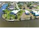 Aerial view of waterfront property with pool, dock, lush landscaping, and canal access, ideal for boating at 9404 Arnaz Cir, Port Charlotte, FL 33981