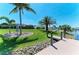 A dock is next to a lush green yard with a signpost and palm trees in the backyard at 9404 Arnaz Cir, Port Charlotte, FL 33981