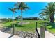 Beautifully landscaped yard featuring a wooden dock and mature palm trees at 9404 Arnaz Cir, Port Charlotte, FL 33981