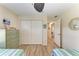 Light-filled twin bedroom has blonde floors, ceiling fan, and a closet across from the beds at 9404 Arnaz Cir, Port Charlotte, FL 33981