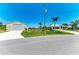 View of a well-maintained home and detached garage with lush landscaping and ample parking at 9404 Arnaz Cir, Port Charlotte, FL 33981