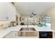 Close-up of the kitchen sink, countertops, and view to dining area with pool views at 9404 Arnaz Cir, Port Charlotte, FL 33981