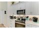Close-up of the range in the kitchen showing light countertops and stainless appliances at 9404 Arnaz Cir, Port Charlotte, FL 33981