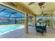 View from the covered patio with dining table and screened-in pool overlooking the canal at 9404 Arnaz Cir, Port Charlotte, FL 33981