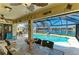 Covered patio features a dining set and a view of the screened-in pool and canal at 9404 Arnaz Cir, Port Charlotte, FL 33981