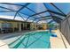 Backyard pool and patio with covered lanai offers sunny skies and views of canal at 9404 Arnaz Cir, Port Charlotte, FL 33981