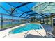 Screened in-ground pool and patio with view of canal, landscaping, and sunny blue sky at 9404 Arnaz Cir, Port Charlotte, FL 33981