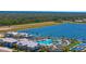 Overhead view of pool and recreational facilities with the lake in the background at 9853 Bright Water Dr, Englewood, FL 34223
