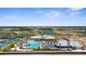 Expansive aerial view of a community with a clubhouse, pool, lake, and many residences at 9853 Bright Water Dr, Englewood, FL 34223