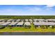 Aerial view of single-Gathering homes with screened lanais, tiled roofs, and lush green lawns near the water at 9853 Bright Water Dr, Englewood, FL 34223