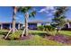 Lush backyard with trees and landscaping, with a view of the screened in back porch of the home at 9853 Bright Water Dr, Englewood, FL 34223