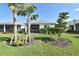 Green backyard featuring lush landscaping, trees, and partial view of screened-in back porch at 9853 Bright Water Dr, Englewood, FL 34223