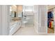 Bright and airy bathroom with double sinks, a walk-in shower, and a glimpse into the walk-in closet at 9853 Bright Water Dr, Englewood, FL 34223
