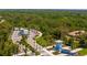 Scenic community entrance featuring palm trees, lush landscaping, and charming blue gatehouses at 9853 Bright Water Dr, Englewood, FL 34223