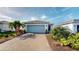 Charming home featuring a paved driveway, well-kept lawn, and vibrant landscaping at 9853 Bright Water Dr, Englewood, FL 34223