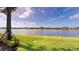 Beautiful lakefront property with well-maintained grass extending to the water's edge and blue skies at 9853 Bright Water Dr, Englewood, FL 34223