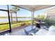 Screened lanai with a grill and serene lake view, perfect for outdoor dining and relaxation at 9853 Bright Water Dr, Englewood, FL 34223