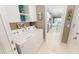 Bright laundry room features white cabinets, modern appliances, and views to the kitchen at 9853 Bright Water Dr, Englewood, FL 34223