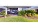 Back patio area with screened in porch, landscaping, and outdoor seating at 9853 Bright Water Dr, Englewood, FL 34223