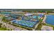 Aerial shot of brand-new pickleball courts with lush landscaping and a community pool in the background at 9853 Bright Water Dr, Englewood, FL 34223