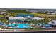 Stunning community pool and clubhouse with lounge chairs, palm trees, and a beautiful lake view at 9853 Bright Water Dr, Englewood, FL 34223