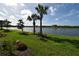 Beautiful water view with lush green grass and stately palms. Great views for this property at 9853 Bright Water Dr, Englewood, FL 34223