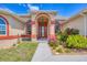 Inviting front entrance with a decorative door, arched window details, and lush landscaping at 10495 Atenia St, Port Charlotte, FL 33981