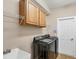 Practical laundry room with modern washer and dryer, along with storage cabinets at 10495 Atenia St, Port Charlotte, FL 33981