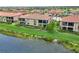 Wonderful back view of villas with tile roofs, screened lanais, well-manicured lawns and lush landscaping near the lake at 10805 Tarflower Dr # 101, Venice, FL 34293