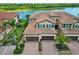 Aerial view of the townhome featuring tile roofs, multiple garages, and a tranquil lake in the background at 10805 Tarflower Dr # 101, Venice, FL 34293
