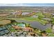 Scenic aerial view of a lakeside community featuring a golf course, swimming pool, and residential homes at 10805 Tarflower Dr # 101, Venice, FL 34293