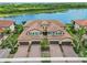 Stunning aerial view of paired villas with tile roofs, garages, paver driveways and lake views at 10805 Tarflower Dr # 101, Venice, FL 34293