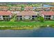 Wonderful back view of villas with tile roofs, screened lanais, well-manicured lawns, and lush landscaping at 10805 Tarflower Dr # 101, Venice, FL 34293