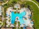 Aerial view of a luxurious community pool with palm trees and lounge chairs at 10805 Tarflower Dr # 101, Venice, FL 34293