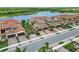 An aerial view of homes situated along a lake, featuring tile roofs, garages and lush landscaping at 10805 Tarflower Dr # 101, Venice, FL 34293