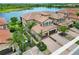 Stunning aerial view of a well-maintained community with tile roofs, paved driveways, and a beautiful lake at 10805 Tarflower Dr # 101, Venice, FL 34293