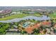 Community aerial view showcasing a pool, clubhouse, golf course, lakes, tennis courts, and residential area at 10805 Tarflower Dr # 101, Venice, FL 34293