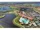 An aerial view of a community clubhouse with a pool, tennis courts, parking and golf course with lakes at 10805 Tarflower Dr # 101, Venice, FL 34293