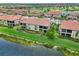 Wonderful back view of villas with tile roofs, screened lanais, well-manicured lawns and lush landscaping near the lake at 10805 Tarflower Dr # 101, Venice, FL 34293