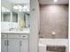 Stylish bathroom with a marble vanity, framed mirrors, and a tiled shower/tub combination at 10805 Tarflower Dr # 101, Venice, FL 34293