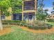 A ground-level view shows the exterior with a screened patio on both levels, surrounded by lush landscaping at 10805 Tarflower Dr # 101, Venice, FL 34293