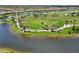 Aerial view of a lush golf course and community lake, highlighting manicured greens and mature trees at 10805 Tarflower Dr # 101, Venice, FL 34293