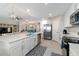 Bright kitchen features white cabinets, stainless steel appliances, large island with bar stool seating, and modern lighting at 10805 Tarflower Dr # 101, Venice, FL 34293