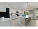 Bright kitchen features white cabinets, stainless steel appliances, large island with bar stool seating, and modern lighting at 10805 Tarflower Dr # 101, Venice, FL 34293