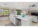 Bright kitchen island with bar stool seating, stainless steel appliances, and views to the living room at 10805 Tarflower Dr # 101, Venice, FL 34293
